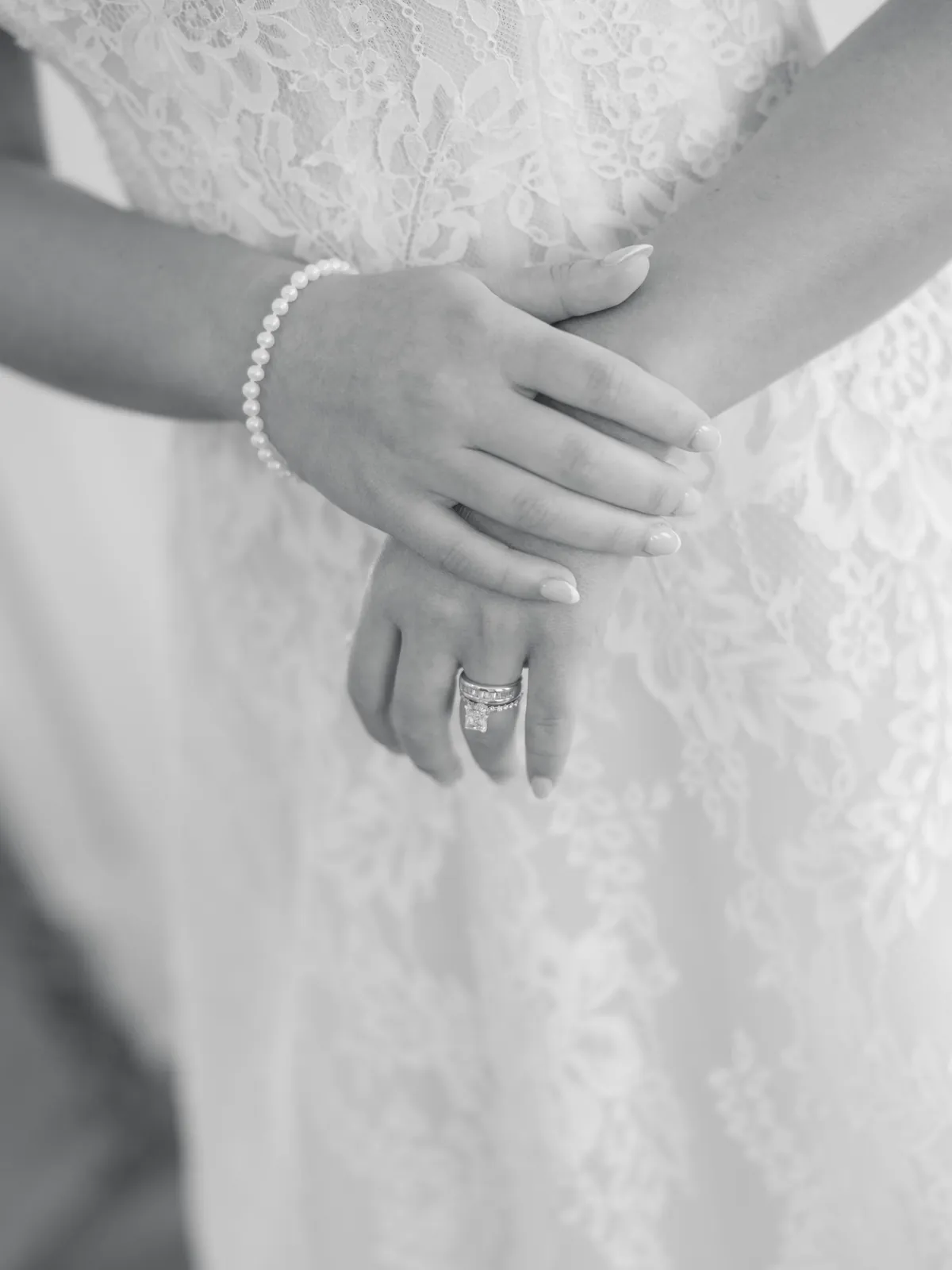 Bride's hands with wedding ring and pearl bracelet